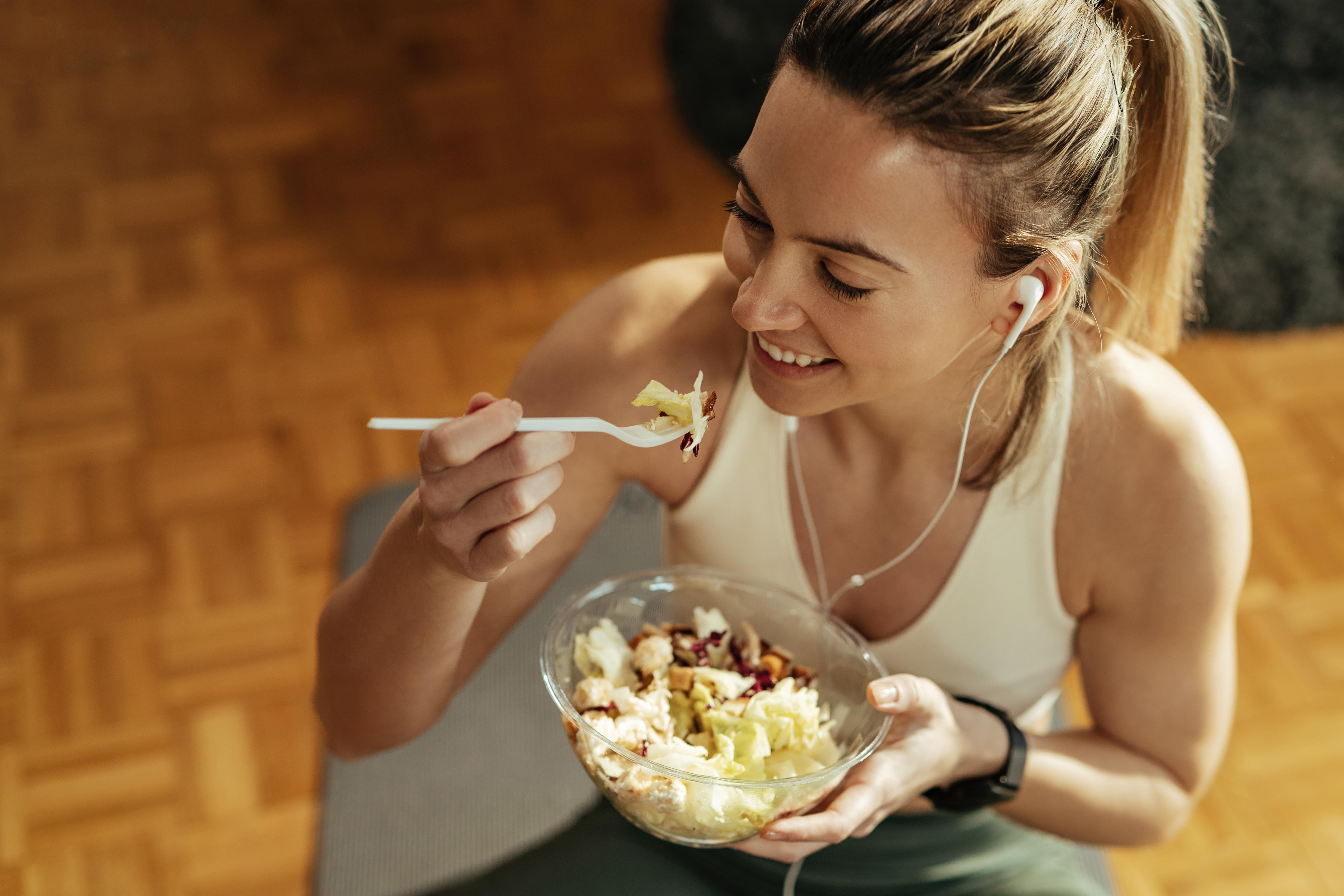 Mujer con ropa deportiva comiendo un plato preparado con arroz