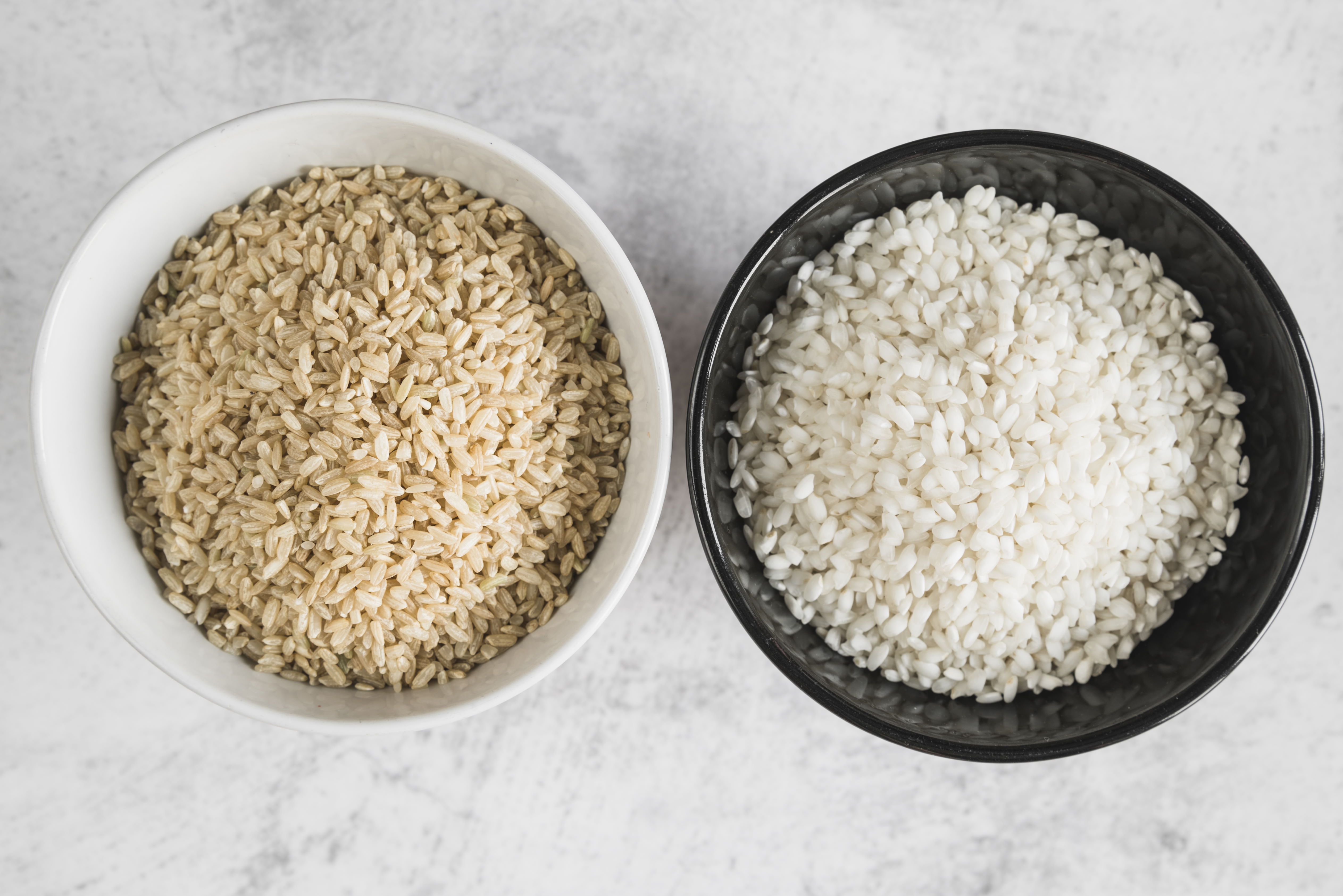 Tazas de arroz integral y arroz blanco