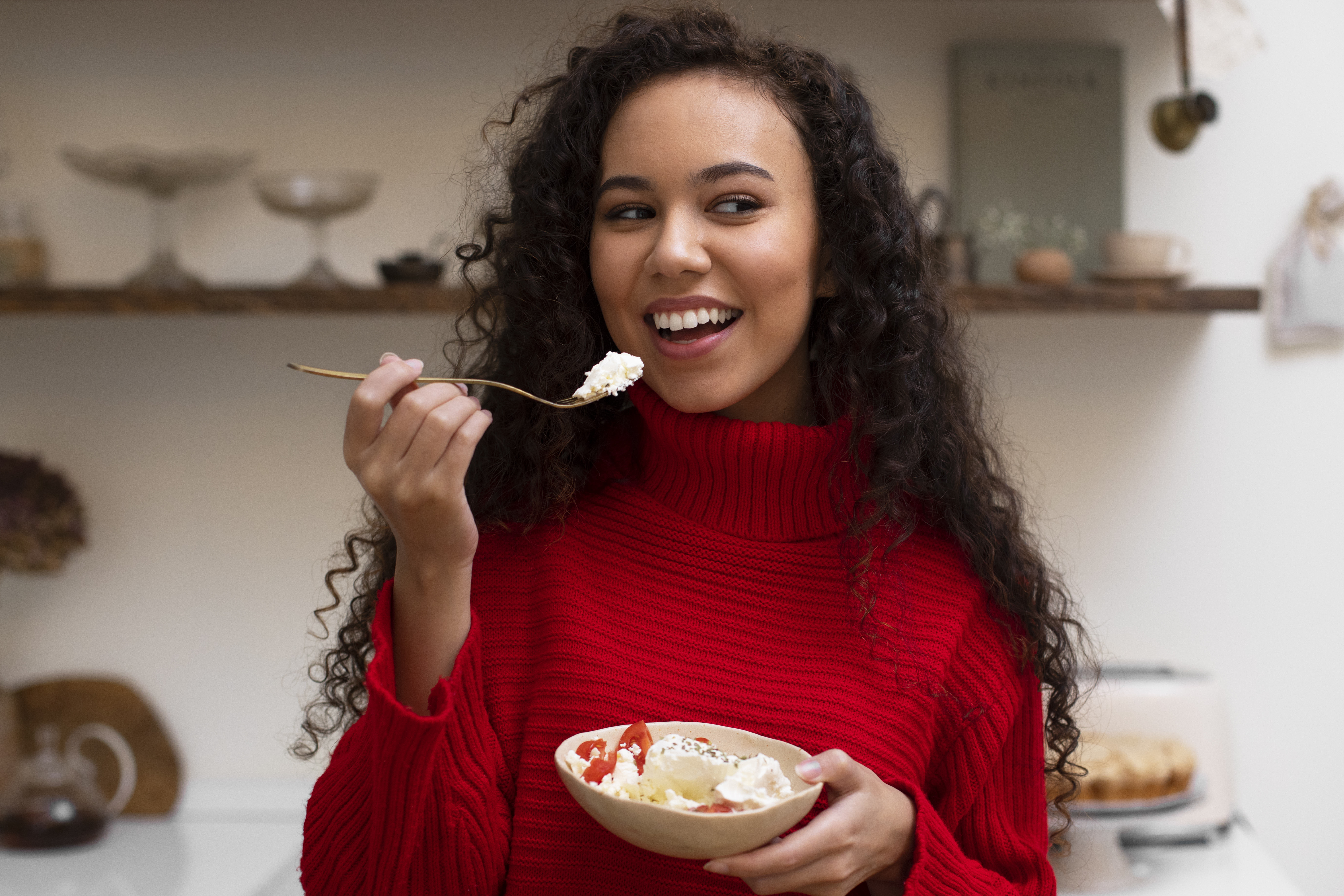 Mujer de sueter rojo comiendo un postre